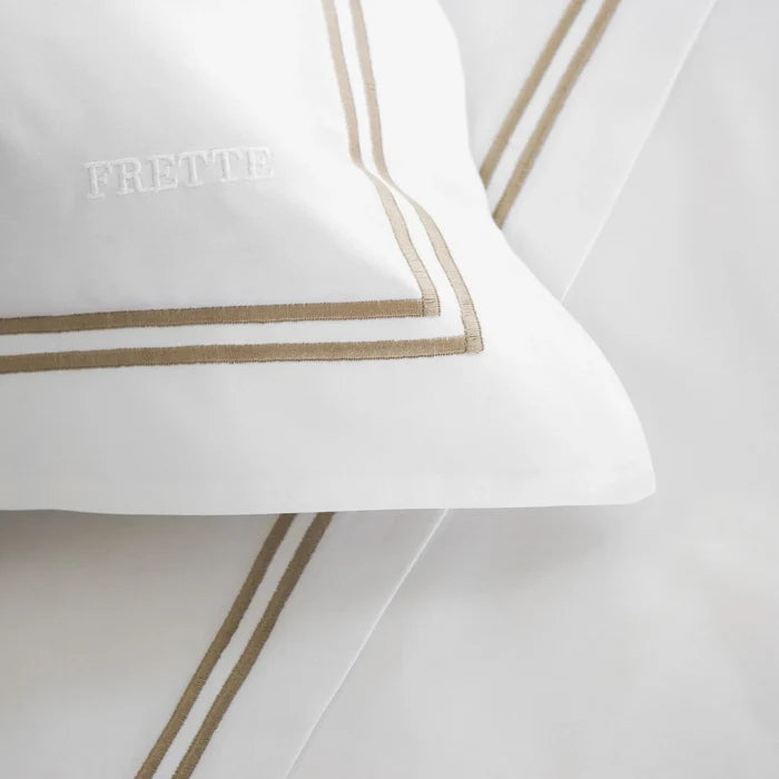 close up of the fabric details of the classic white - khaki pillowcase sham