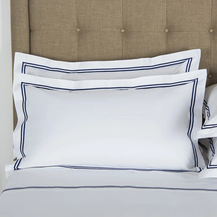 front view of classic pillowcase sham white navy on a bed
