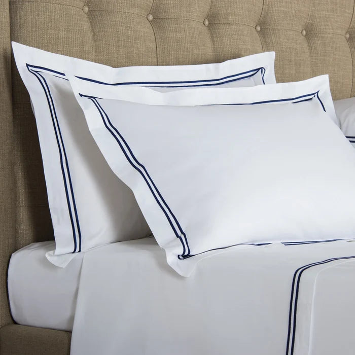 side view of classic pillowcase sham white navy on a bed