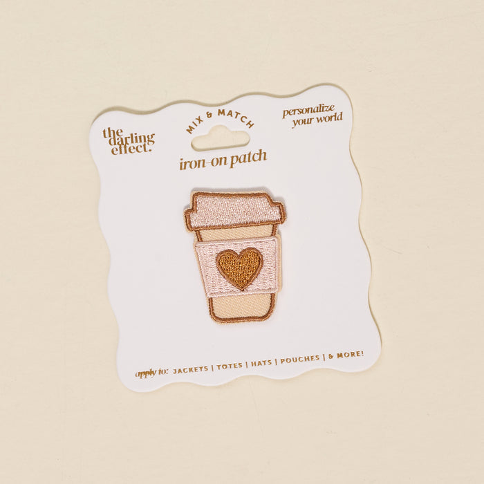 The Darling Effect Coffee Cup Mix & Match Iron-On Patch features a colorful to-go coffee cup with a heart on its sleeve, displayed on a white backing card with text.