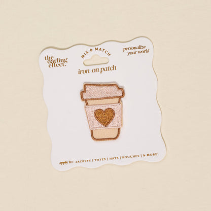 The Darling Effect Coffee Cup Mix & Match Iron-On Patch features a colorful to-go coffee cup with a heart on its sleeve, displayed on a white backing card with text.