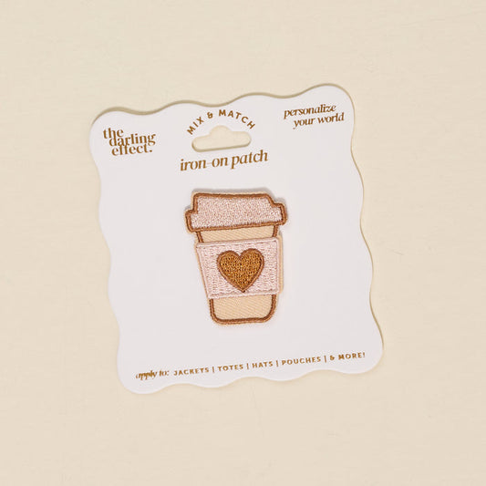 The Darling Effect Coffee Cup Mix & Match Iron-On Patch features a colorful to-go coffee cup with a heart on its sleeve, displayed on a white backing card with text.