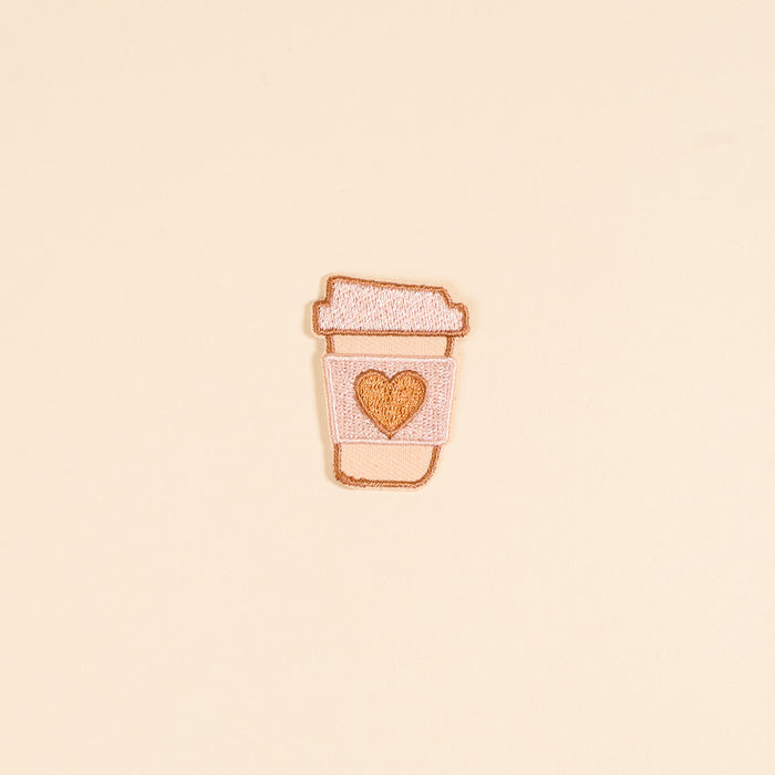 The Darling Effect's Coffee Cup Mix & Match Iron-On Patch features a light pink embroidered cup with a golden heart on a light yellow background—perfect for adding colorful flair to your collection.