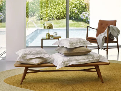 Wooden bench with Copacabana pillowcase sham in a modern room with a view of greenery