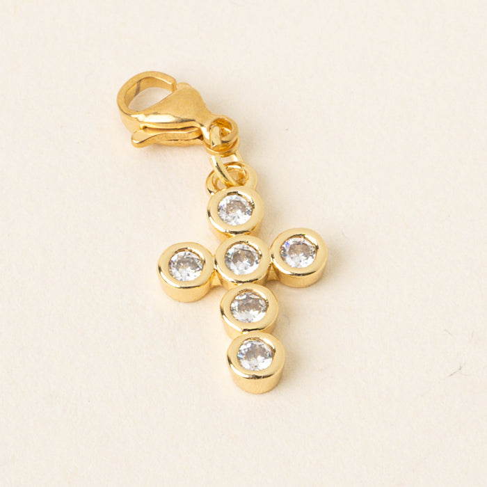 The-darling-effect Cross Jewelry Charm Gold features a gold cross with six clear round gemstones in gold bezels and a lobster clasp—ideal as a bracelet or necklace charm—displayed on a light background.