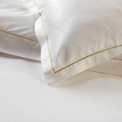 Close-up of Dalia cream/gold pillowcase sham on a white background