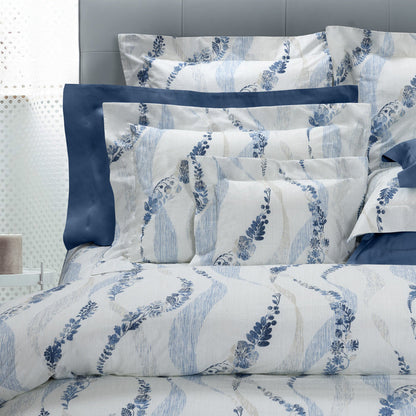 Daria pillowcase sham and duvet cover on a bed with a gray headboard.
