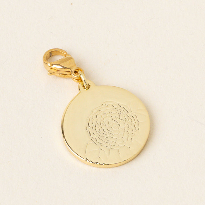 The December Jewelry Birth Flower Charm Gold by the-darling-effect is a round gold pendant with an engraved floral design and lobster clasp—an ideal personalized accessory, beautifully displayed on a light background.