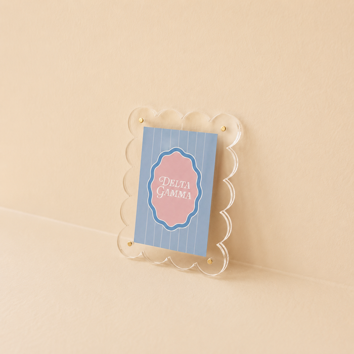 The Darling Effect’s Delta Gamma Mini Acrylic Picture Frame Magnet features a scalloped clear frame, blue striped card, and pink Delta Gamma label—an ideal sorority accent for your fridge.