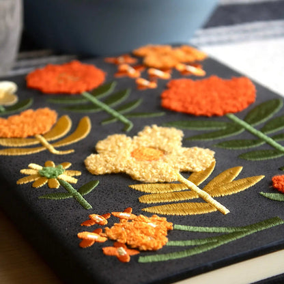 Forager Provisions LTD Denik journal with a black cover featuring textured chunky folk-style embroidered flowers.