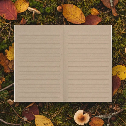 Denik Trout Kraft Classic Layflat Notebook open on fall leaves, moss, twigs, and mushrooms; nature-inspired stationery scene.