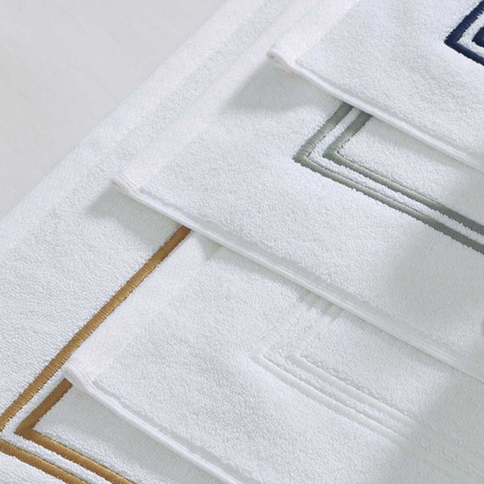 Close-up of Empire Bath Mat White Navy on a light gray background