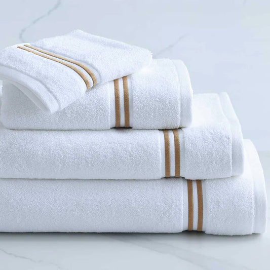 Stack of Empire Towel and Sheet White Gold on a light gray background