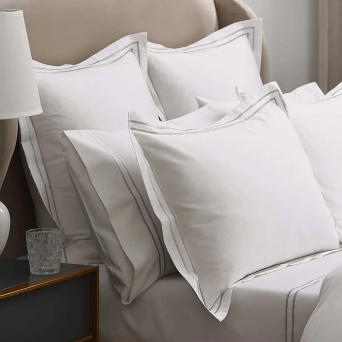 Empire Silver Duvet Cover set on a bed with a side table and lamp in a cozy room setting.