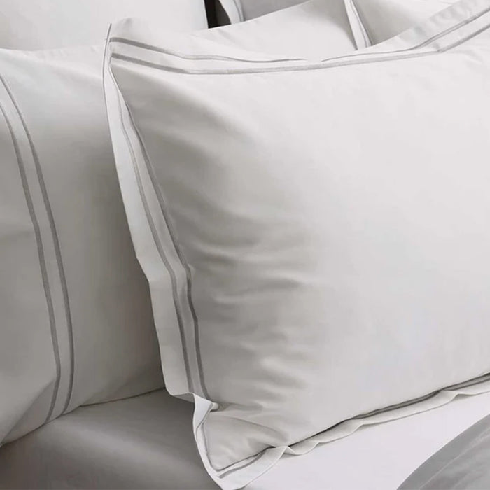 Close-up of Empire Silver Duvet Cover set on a bed with a white background