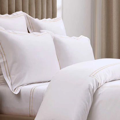 Close-up of Empire Champagne Pillowcases on a bed.