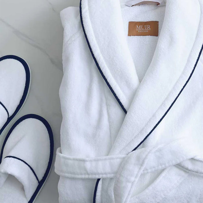 Empire Velour White / Navy Bath robe and 'Muir' brand label next to white slippers with navy trim.