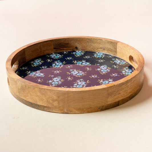 The-darling-effect’s Endless Daydream Navy Large Round Wood Enamel Tray features handles and a floral interior with blue flowers on a dark purple background, making it an elegant serving tray for any setting.