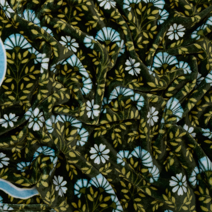 The Darling Effect's Everbloom Forest Green Snuggle Up Plush Blanket features dark green velvet with a vintage floral design in white, blue, and yellow—perfect for cozying up in style.