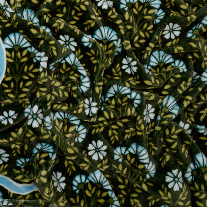 The Darling Effect's Everbloom Forest Green Snuggle Up Plush Blanket features dark green velvet with a vintage floral design in white, blue, and yellow—perfect for cozying up in style.