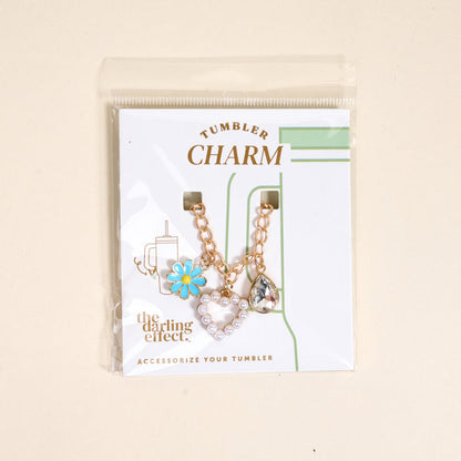 The Darling Effect’s Fairytale Tumbler Charm set features a blue daisy, pearl heart, and crystal teardrop on gold chains—the ideal way to add flair to your favorite tumbler.