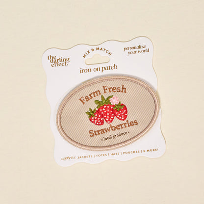 Customize your style with The Darling Effect’s Farm Fresh Strawberries Mix & Match Iron-On Patch, featuring embroidered strawberries and "Farm Fresh Strawberries • local produce" on beige fabric, displayed on branded white packaging.
