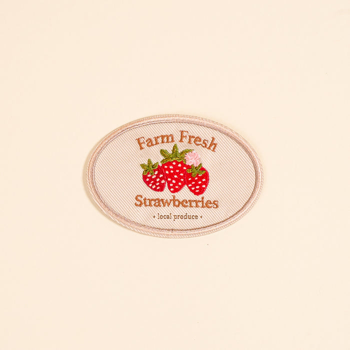 The Darling Effect's Farm Fresh Strawberries Mix & Match Iron-On Patch features embroidered red strawberries and green leaves with the text "Farm Fresh Strawberries"—a vibrant accessory to customize your style.
