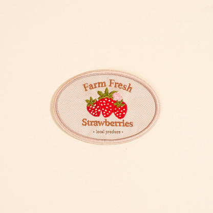 The Darling Effect's Farm Fresh Strawberries Mix & Match Iron-On Patch features embroidered red strawberries and green leaves with the text "Farm Fresh Strawberries"—a vibrant accessory to customize your style.