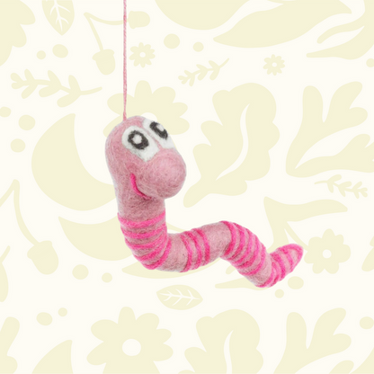 Forager Provisions LTD handmade pink felt worm decoration with striped pattern and hanging string on floral background