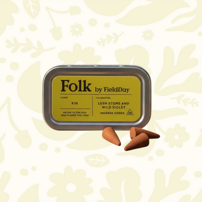 FieldDay Ireland Kin Folk Incense tin and 3 cones, floral backdrop, evokes Irish countryside scents, home fragrance decor.