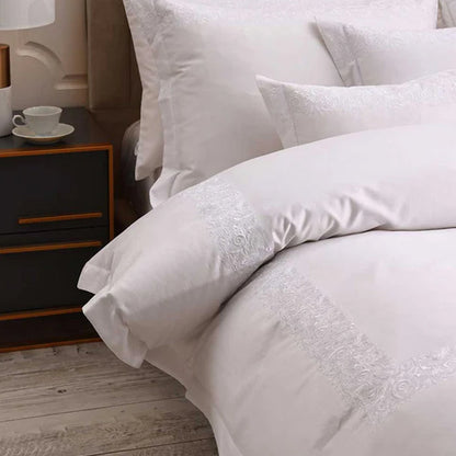 Fion White Duvet Cover Set on a bed in a bedroom setting.