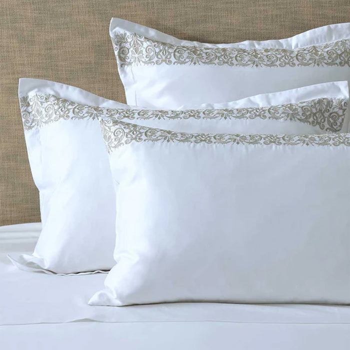 Fion Taupe Pillowcases on a bed against a beige headboard.