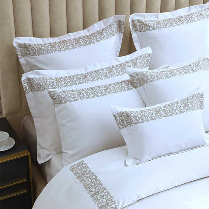 Fion Taupe Pillowcase on a bed against a beige headboard.