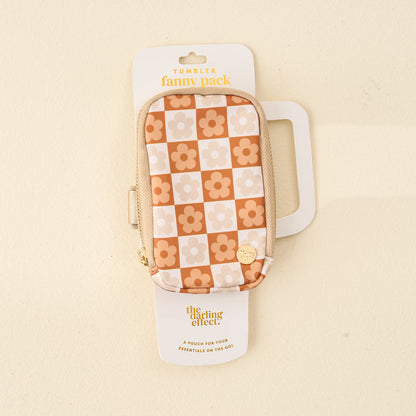 The Darling Effect’s Flower Check Brown Tumbler Fanny Pack is a stylish, water-resistant pouch with a beige zipper and retro orange and cream checkerboard flower pattern, shown packaged against a light background.