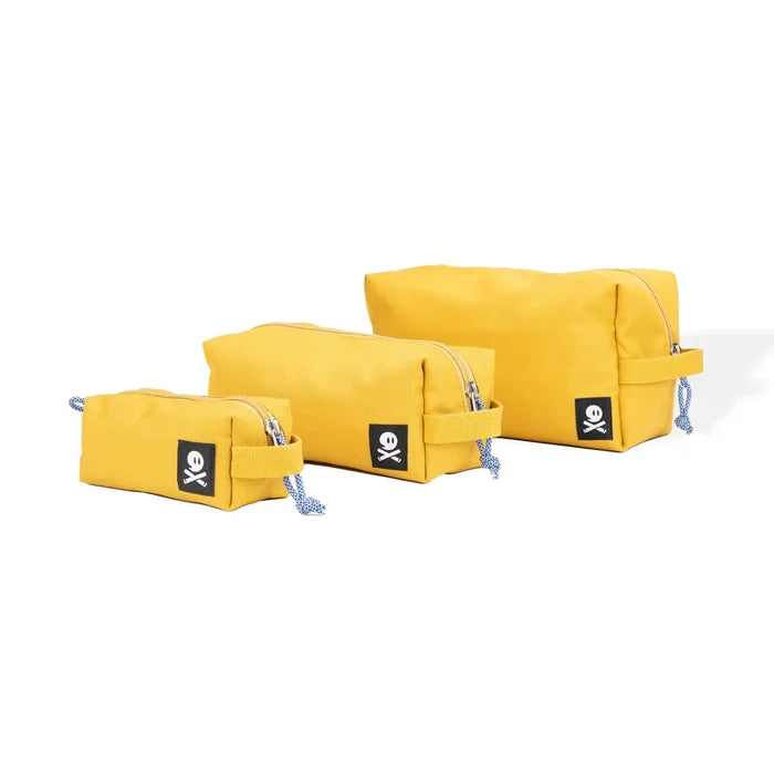 Three Ghost Outdoors Dopp Kits in ochre yellow, side handles, black OK tags, neatly displayed side-by-side for travel.