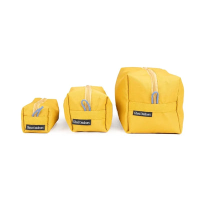 Ghost Outdoors Dopp Kits in ochre yellow, set of three toiletry bags, neatly arranged on clean white background.