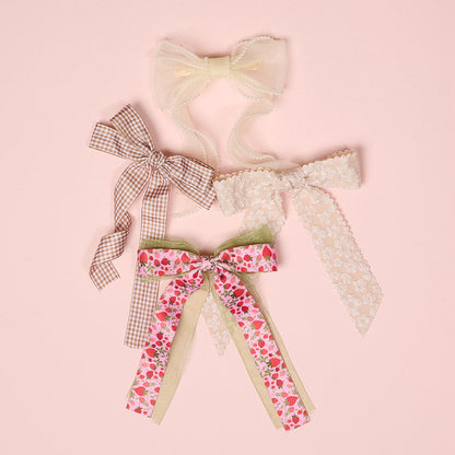 The Darling Effect Gingham Tan Double Take Hair Bow adds a touch of elegance to any look with its chic tan gingham print—perfect as a stylish hair accessory.