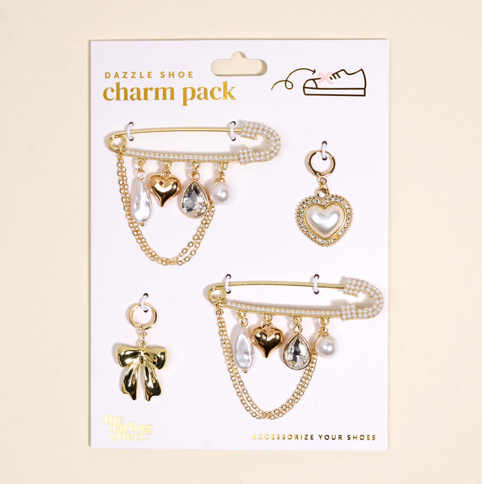 The Darling Effect’s Glitz & Glam Dazzle Shoe Charm Pack features two embellished pins with dangling hearts, bows, pearls, and teardrop gems plus two individual charms—a heart and a bow—ideal for adding stylish flair to your shoes.