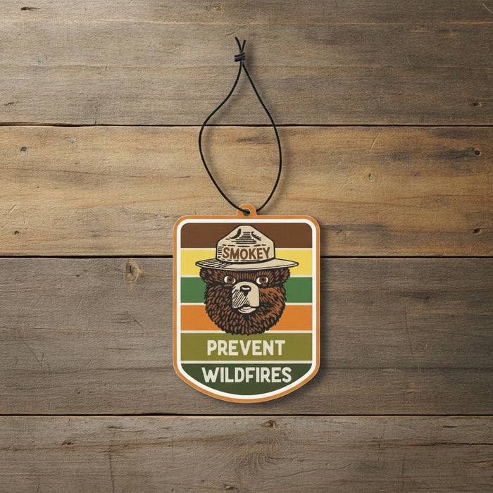 Forager Provisions LTD Smokey Bear hanging air freshener with retro pine and citrus design on a rustic wood background