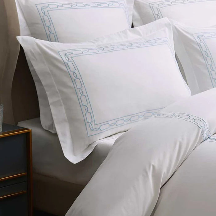 Hamilton Light Blue Duvet Cover Set on a bed with a side table in the background
