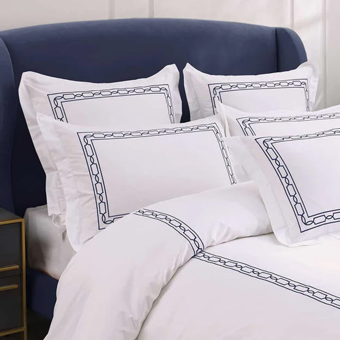 Hamilton Navy Duvet Cover Set on a bed with a blue headboard.