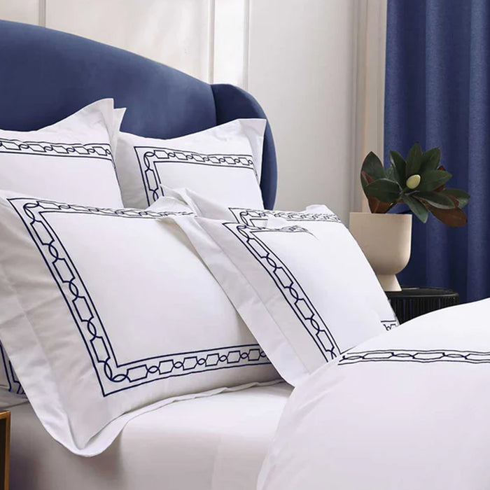 Hamilton Navy Pillowcase on a bed in a bedroom setting.