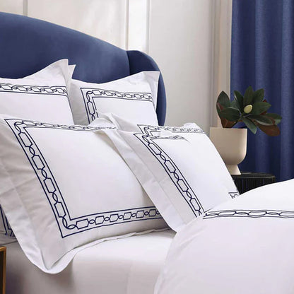Hamilton Navy Pillowcase on a bed in a bedroom setting.