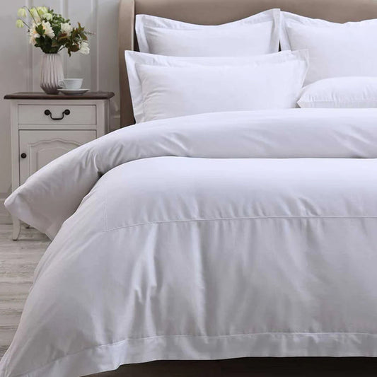 Heirloom Picot White Stitch Duvet Cover Set on a bed with a nightstand and flowers in the background
