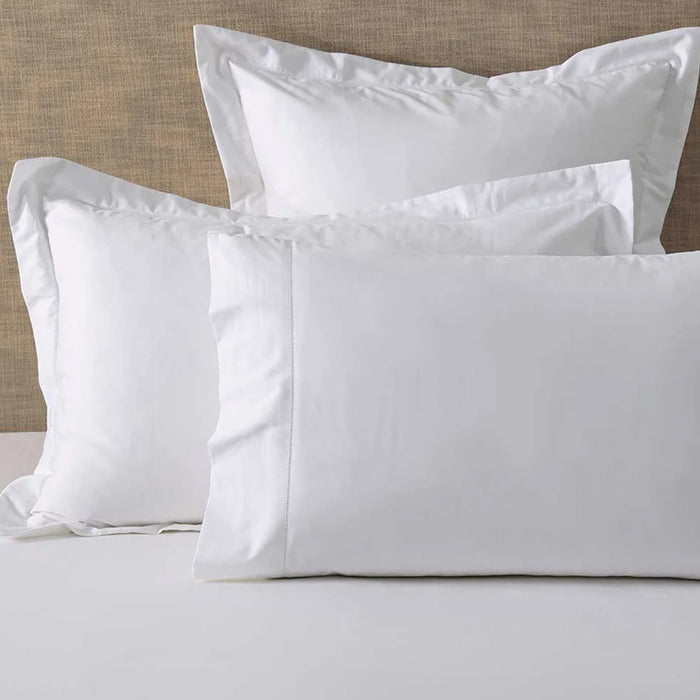 Heirloom Picot Stitch White Pillowcase on a bed with a neutral headboard