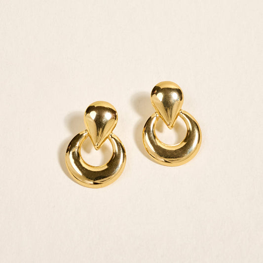 The Darling Effect’s Heirloom Standout Earrings feature a teardrop-shaped stud with a circular hoop below, showcased on a light neutral background—ideal for those who love statement jewelry.