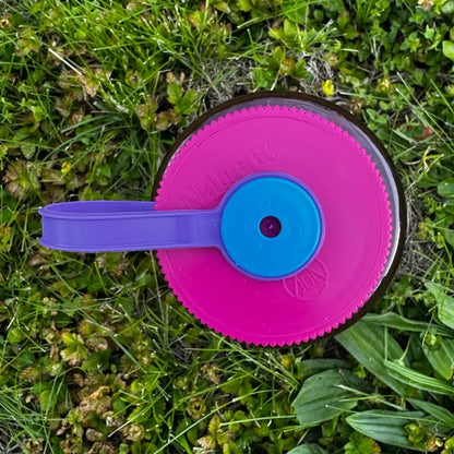Hey Bear Outdoors “Respect The Locals” 32oz Nalgene bottle with purple handle on green grass, perfect for hiking or camping.