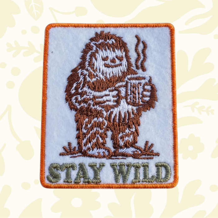 Forager Provisions LTD embroidered iron-on patch featuring a brown Bigfoot drinking coffee with Stay Wild text.