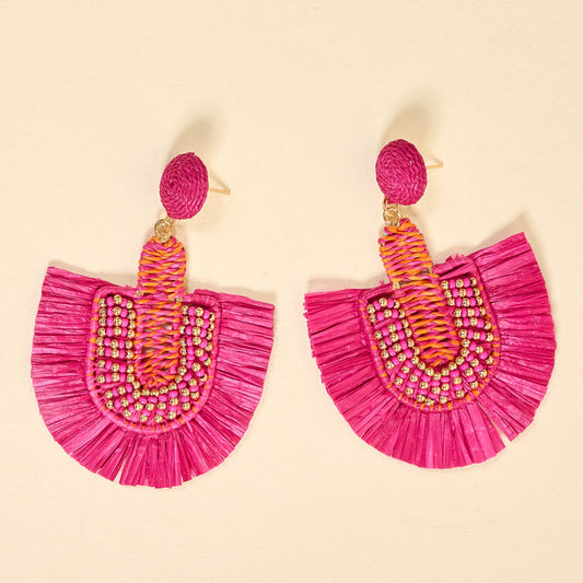 The Darling Effect's Hot Pink Fringe Earrings feature fan-shaped fringes, detailed beadwork, and woven accents for everyday style, shown against a light beige background.
