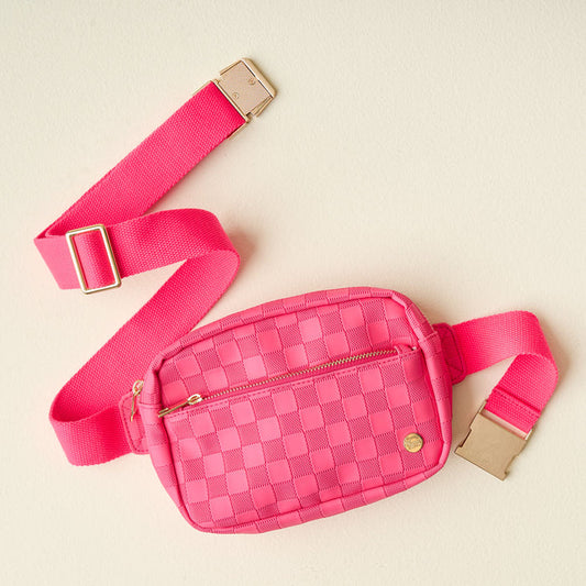 The Darling Effect's Hot Pink Urban Check Belt Bag, made from vegan leather, features a checkered pattern, zippered front pocket, gold zipper, adjustable strap, and gold buckle—an eye-catching accessory displayed on a light beige background.